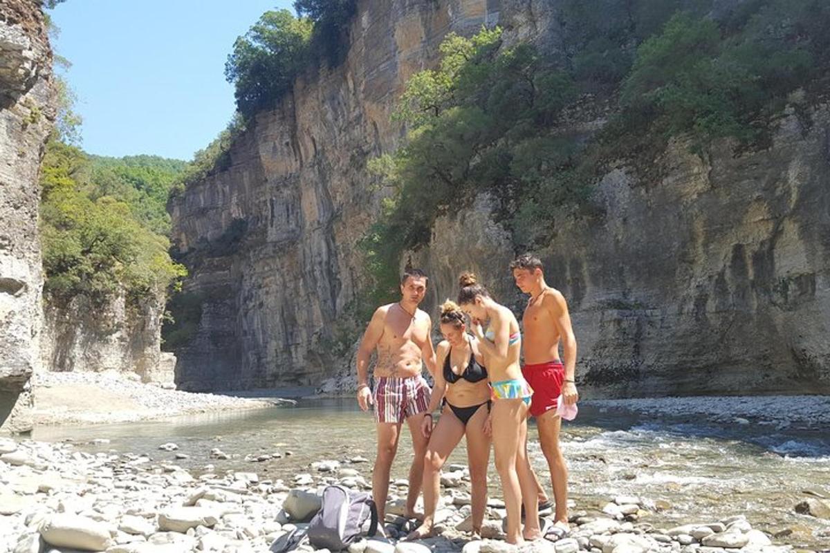 skupina lidí stojících na skalnaté pláži