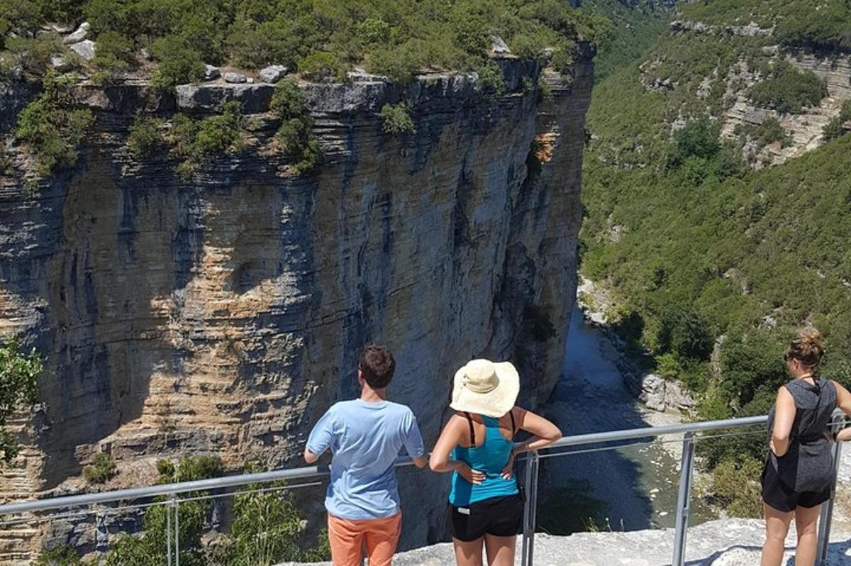un gruppo di persone in piedi su una sporgenza che guarda un canyon
