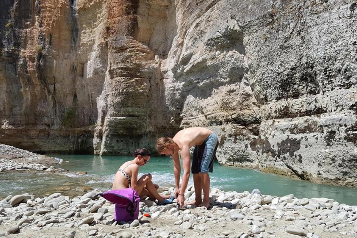 due persone sono in piedi sulle rocce vicino a un fiume