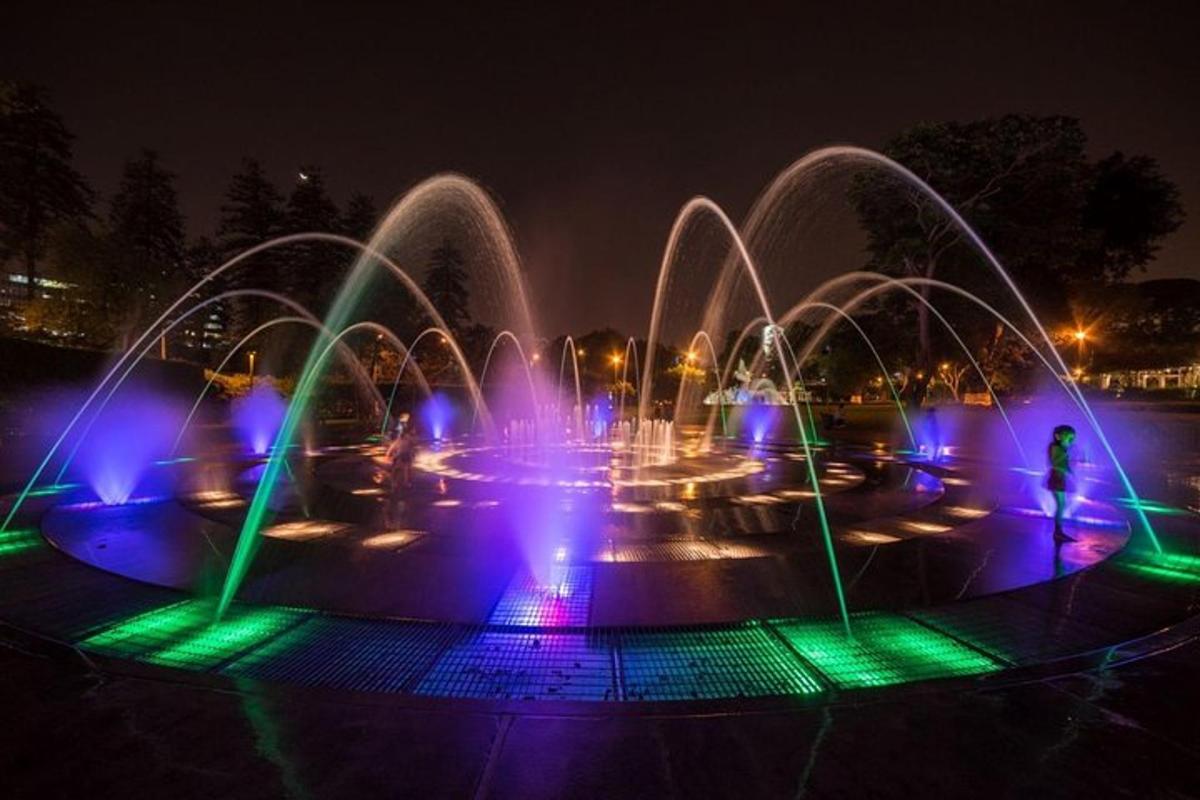 una fontana con luci blu e verdi di notte