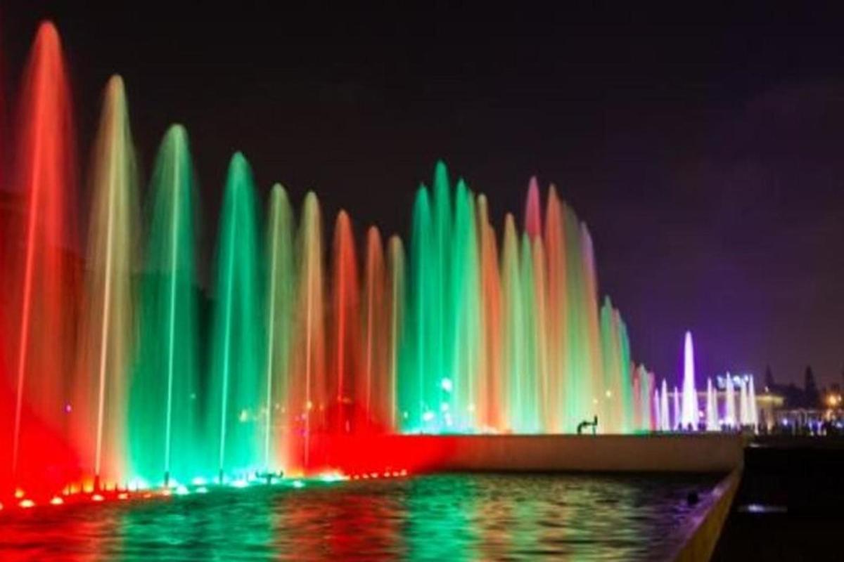 a fountain with colored lights in the water at night