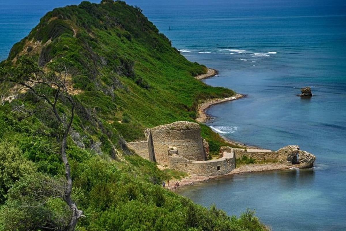 o clădire veche pe un deal lângă ocean