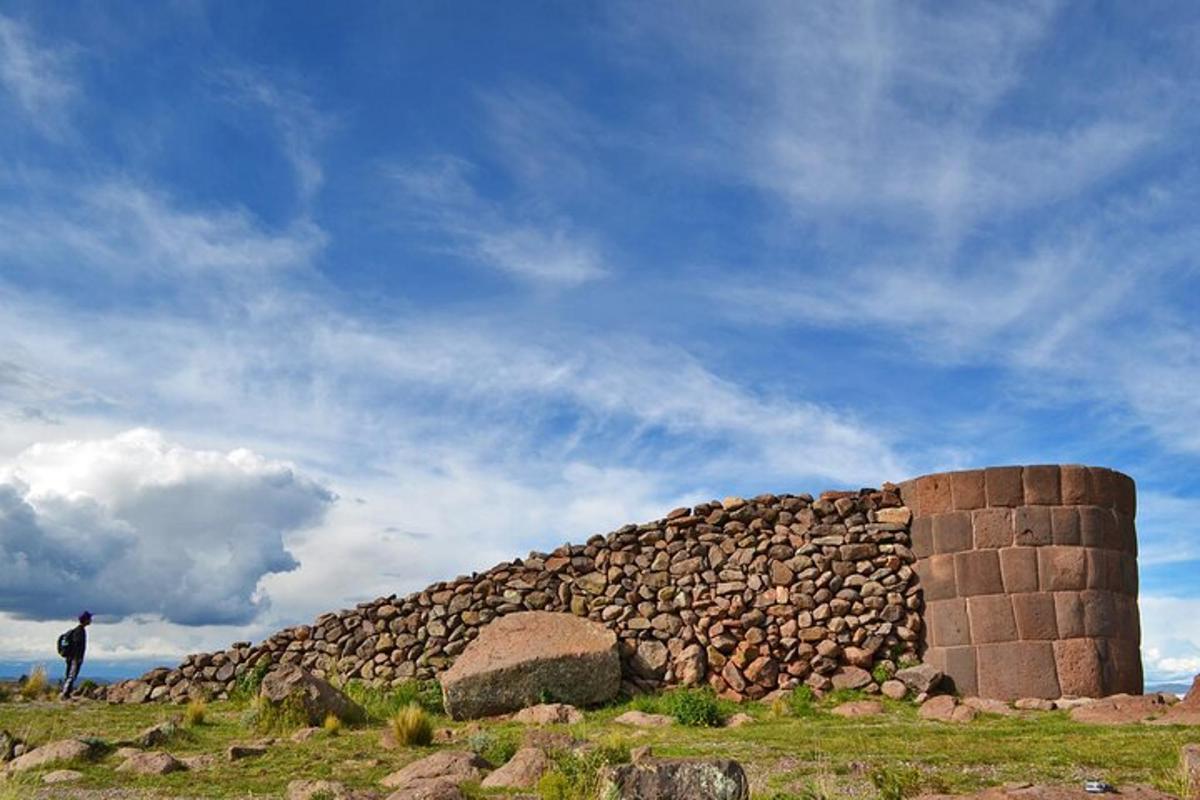 a man standing next to a stone wall