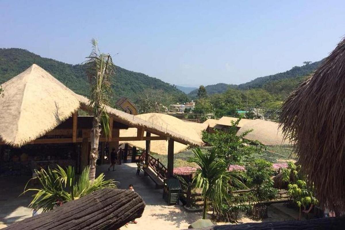 a group of buildings with straw umbrellas on a beach