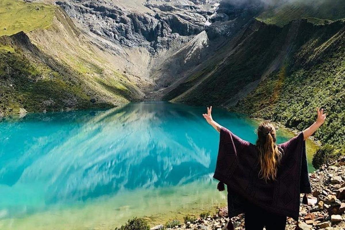 žena stojící na vrcholu hory s výhledem na jezero