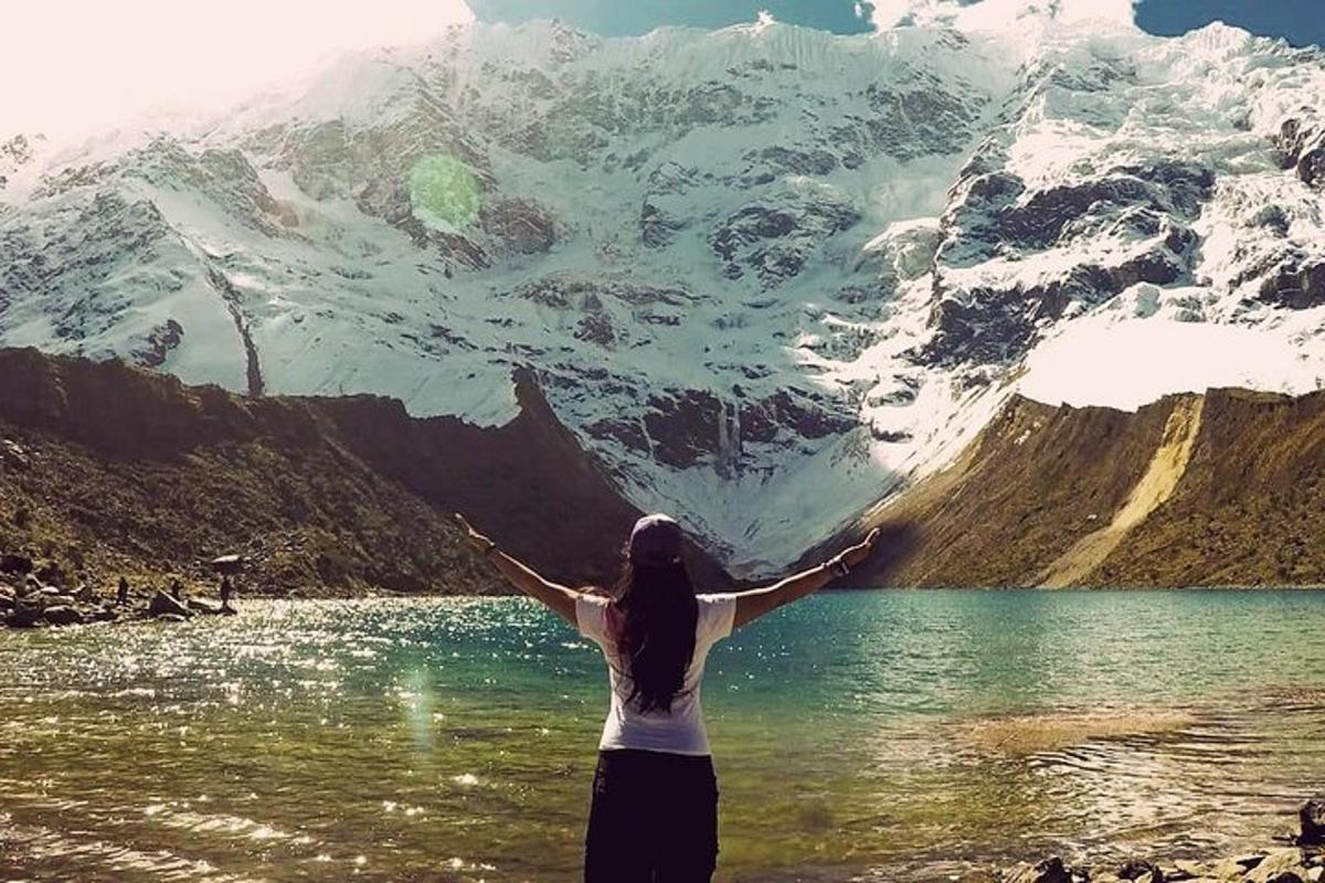 una donna in piedi nell'acqua vicino a una montagna