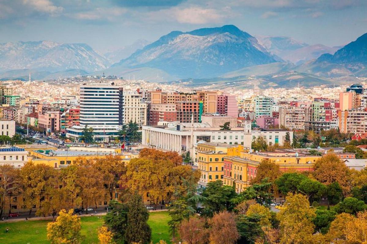 un oraș cu munți în fundal, cu copaci și clădiri