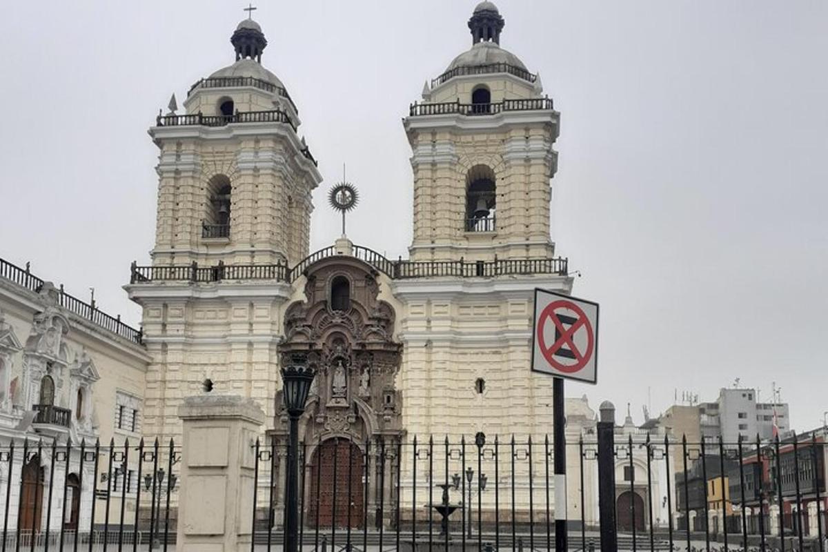 un edifici amb una torre de rellotge davant d'una tanca