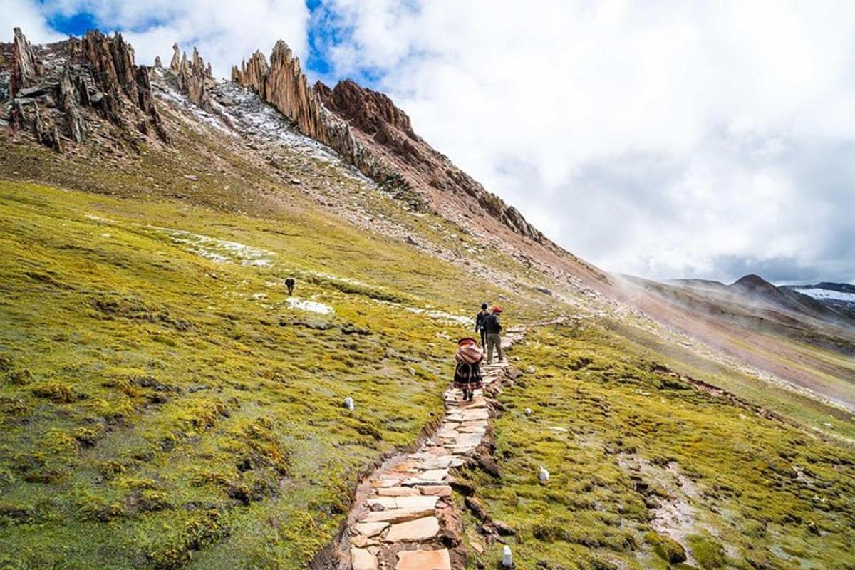 un uomo che cammina lungo un sentiero su una montagna