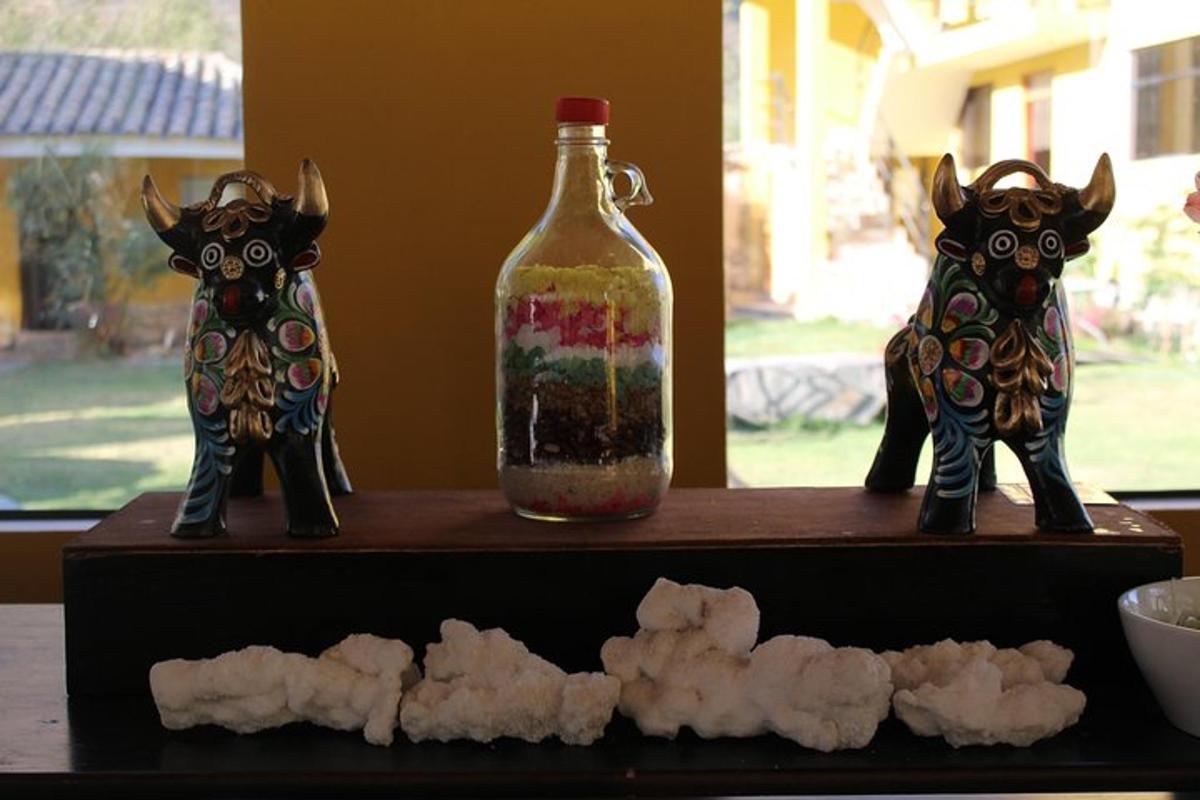 two glass animals sitting on a shelf next to a bottle