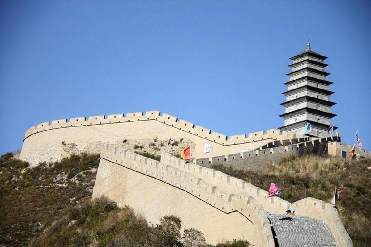 a large wall and a chinese building on a hill