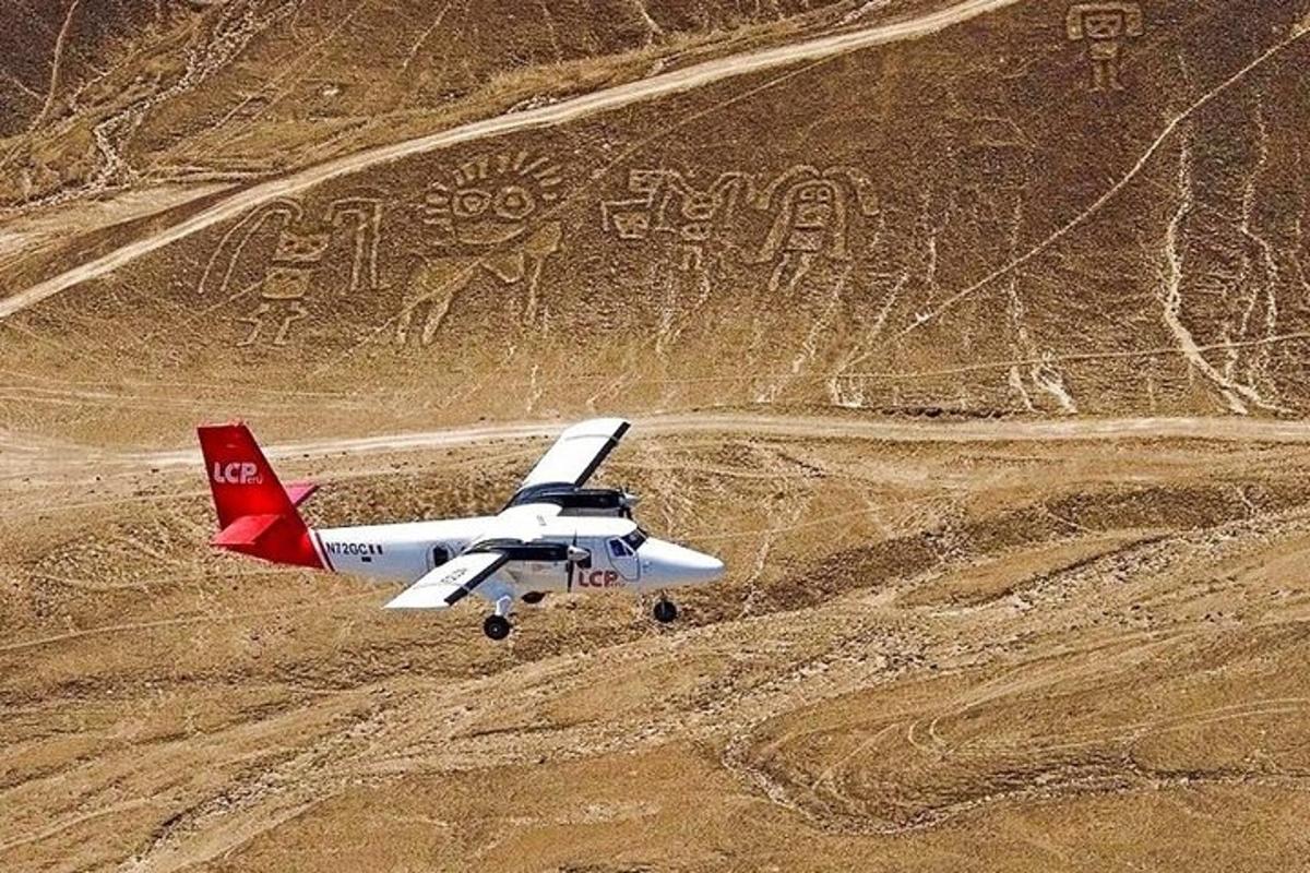 un piccolo aereo sta volando sopra un campo sterrato