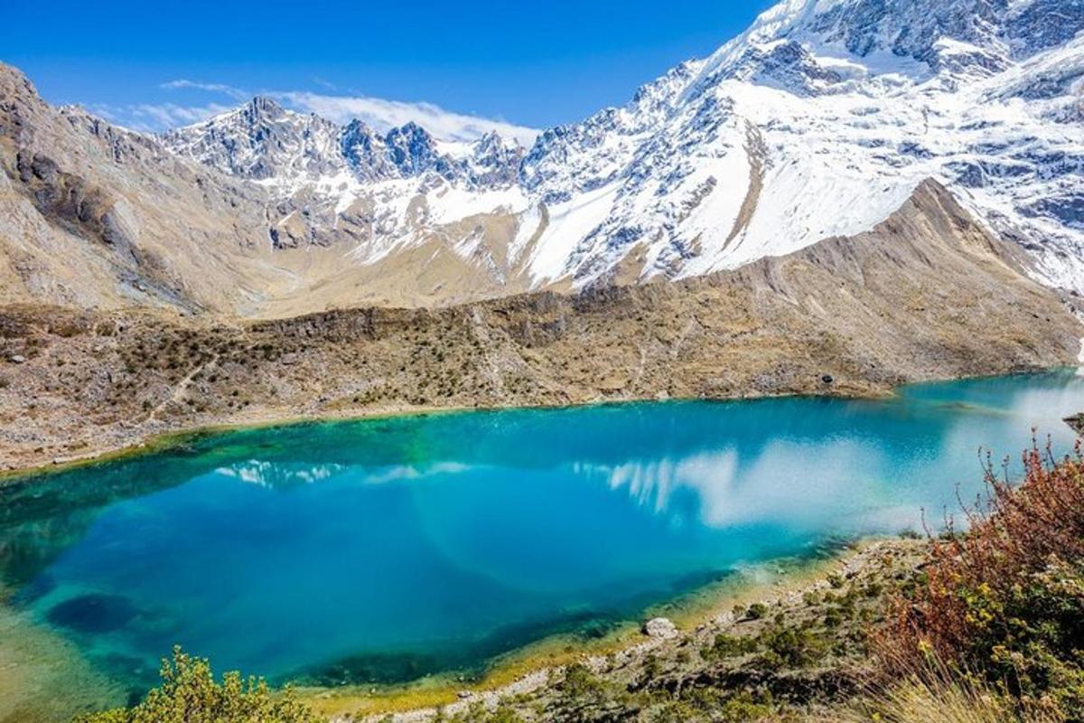 un lago blu in mezzo a una montagna innevata