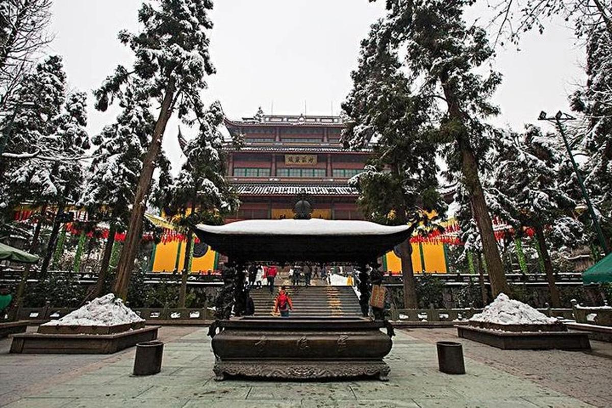 a person standing in front of a building with a fountain