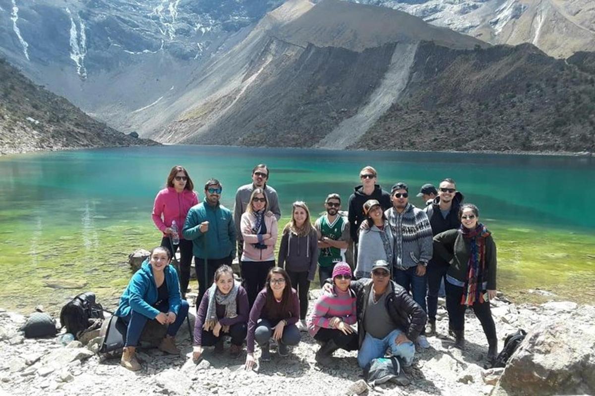 um grupo de pessoas posando em frente a um lago