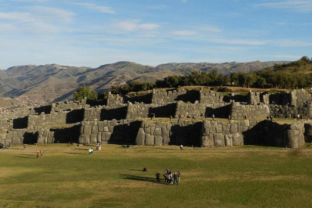 un gruppo di persone in piedi davanti a un muro di pietra