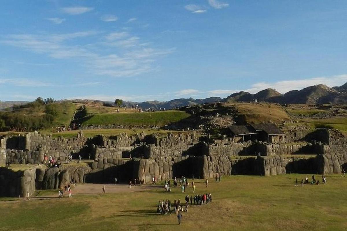 un gruppo di persone in piedi in un campo accanto ad alcune rocce