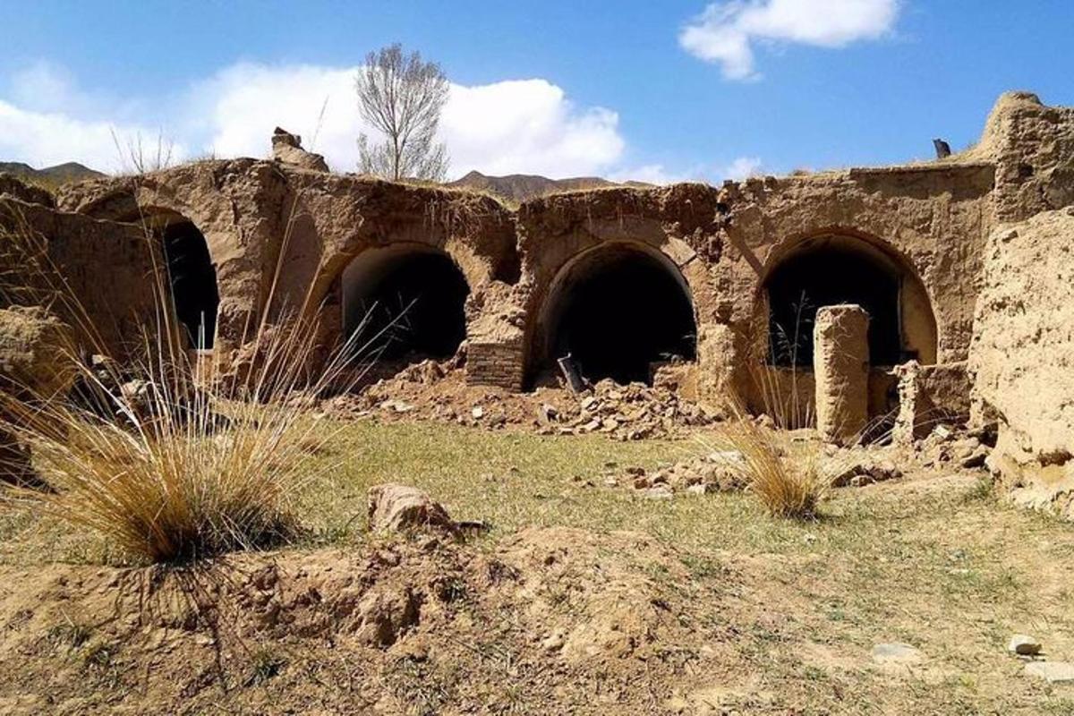 un vecchio edificio con tre tunnel in un campo