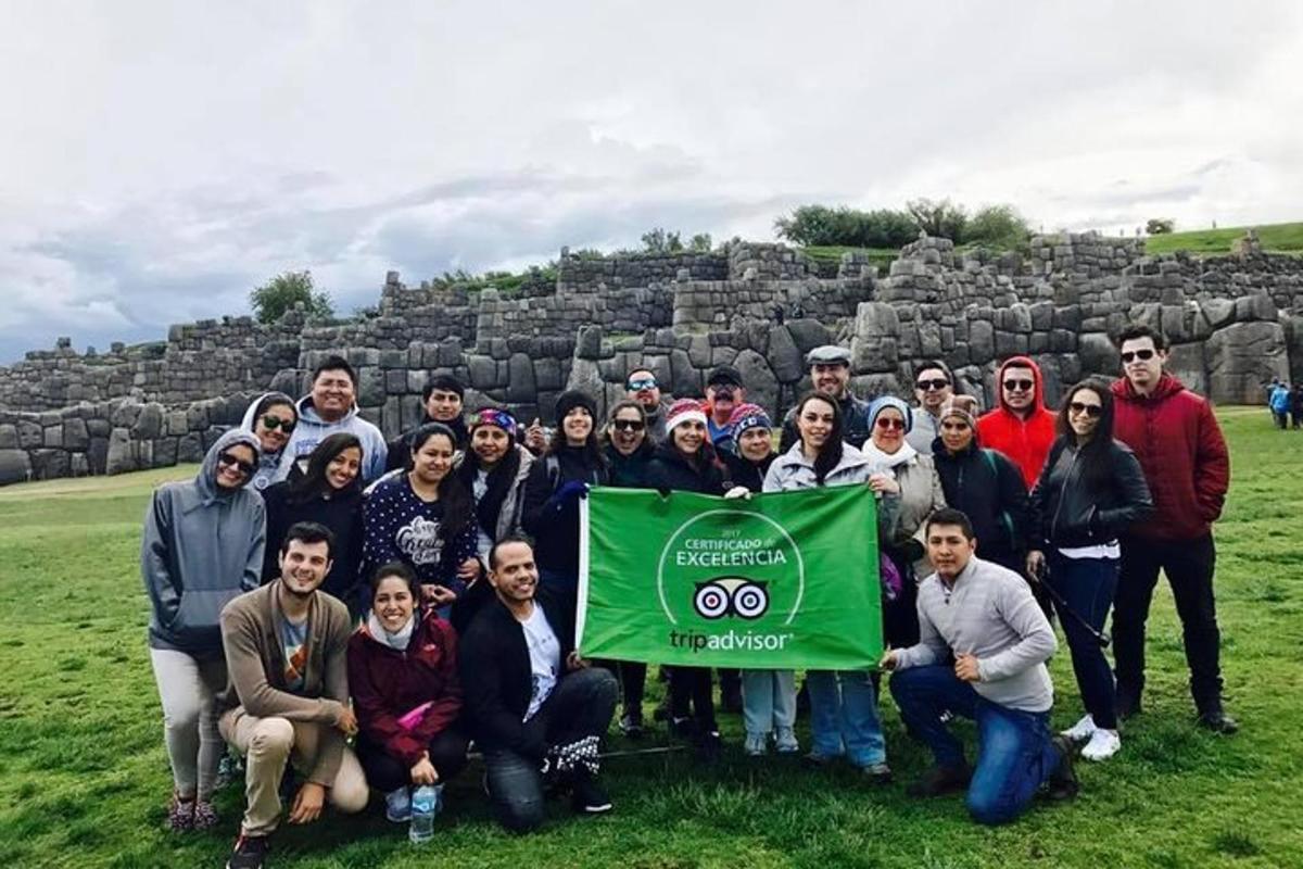 um grupo de pessoas posando para uma foto com uma bandeira verde