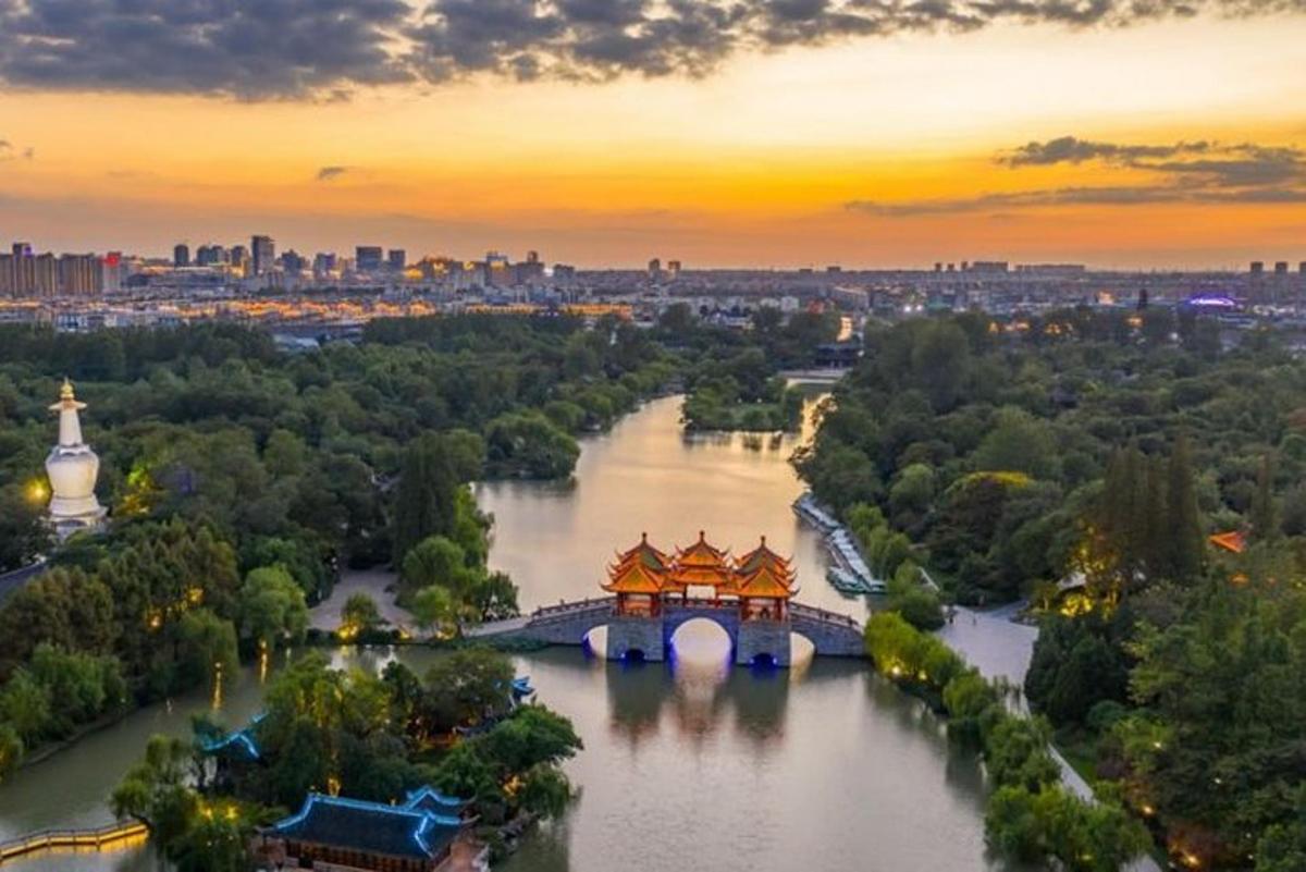 a bridge over a river with a city in the background