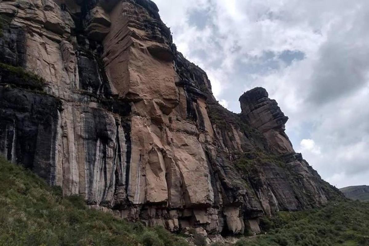 uma grande montanha rochosa no topo de uma colina