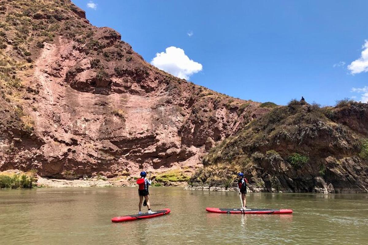 dva lidé stojí na paddleboardech ve vodě