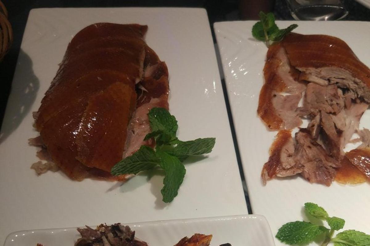 ein weißer Teller mit einem Stück Fleisch und Minze darauf