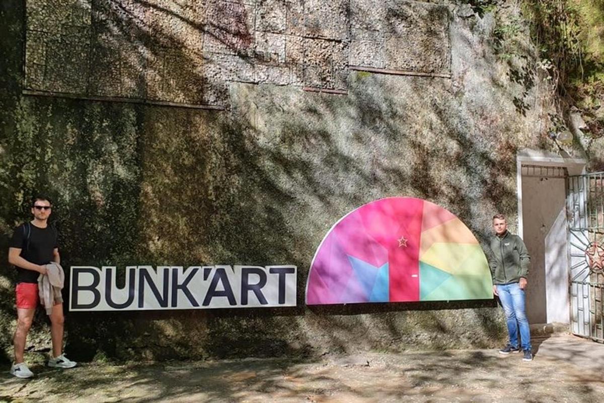 dva muži stojící před zdí s duhou