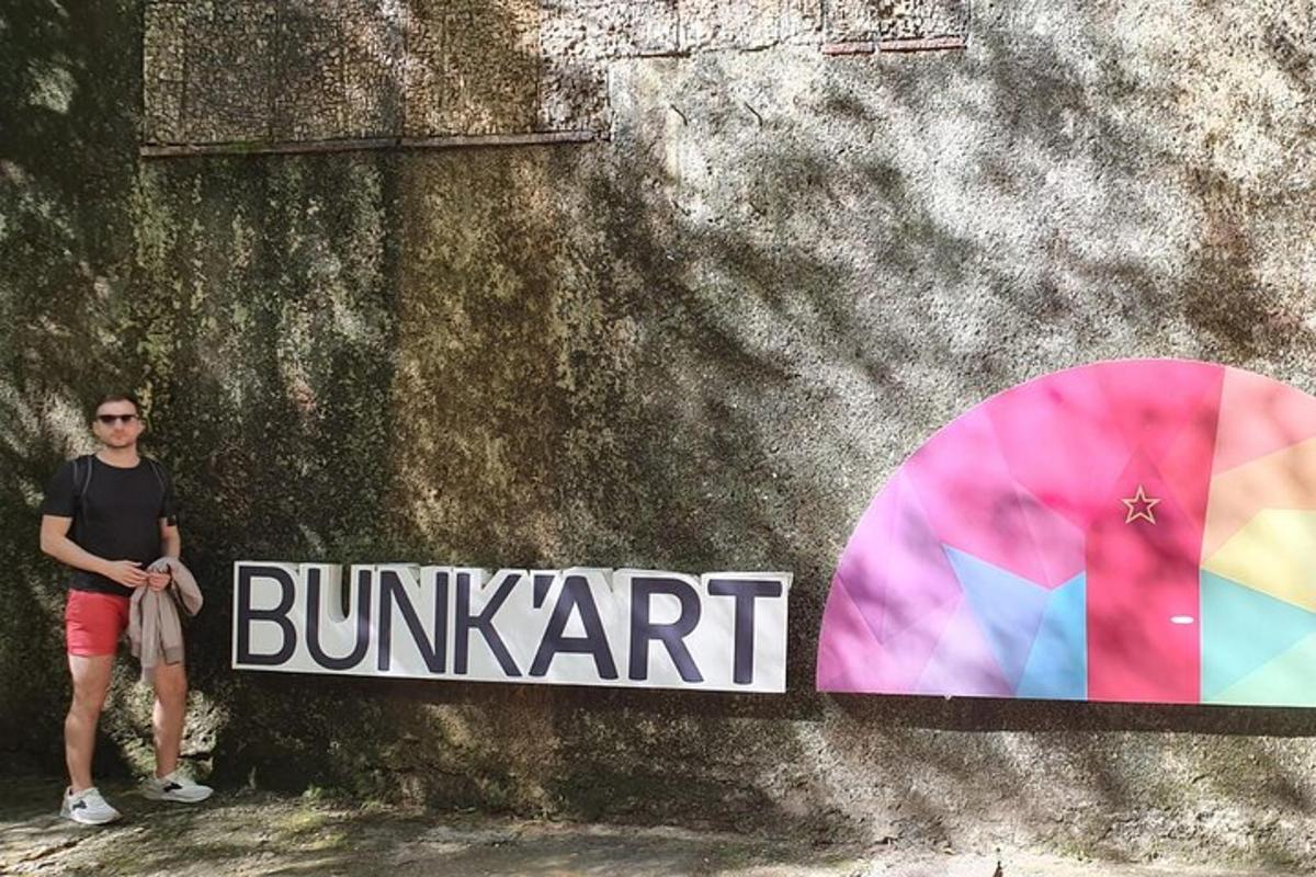 Ein Mann steht neben einem Schild an einer Wand