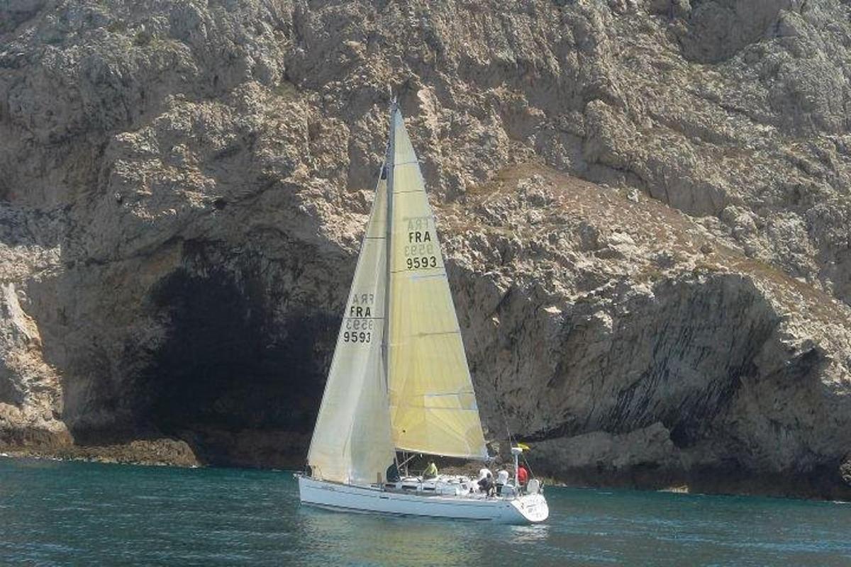 una piccola barca a vela in acqua vicino a una montagna