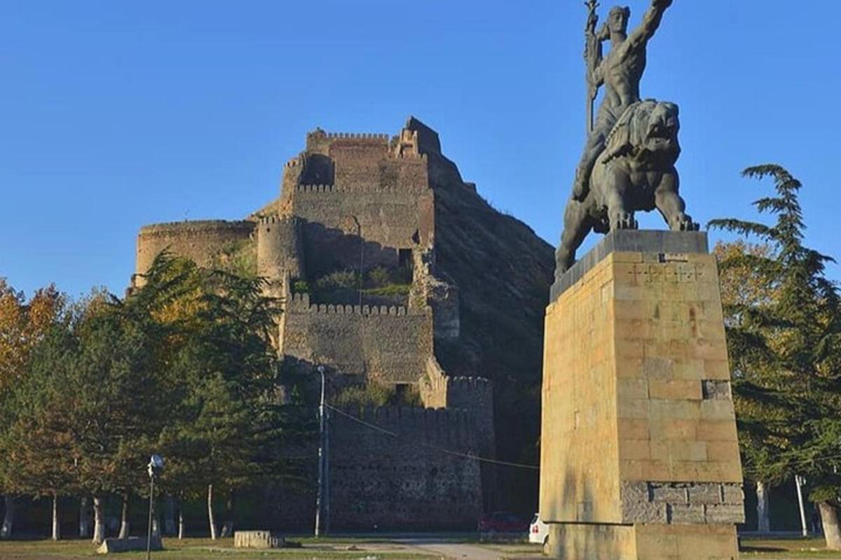 una statua davanti a un grande castello