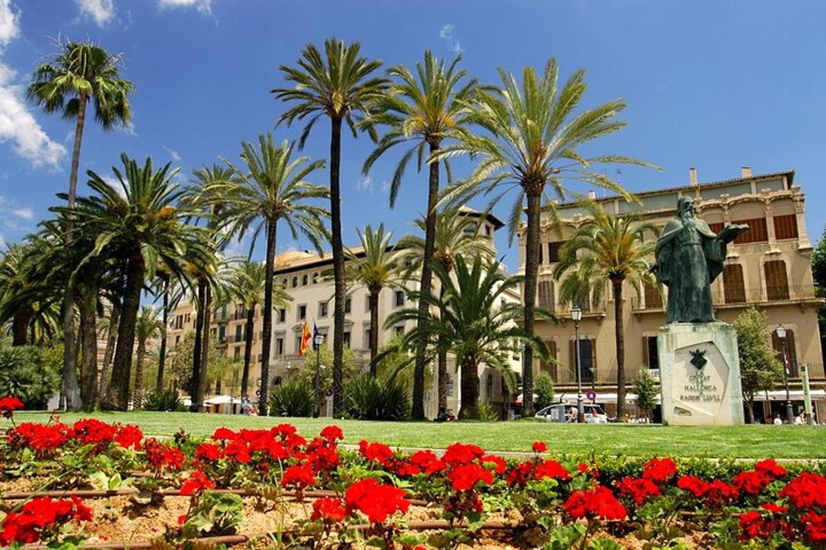 una statua in un parco con fiori e palme