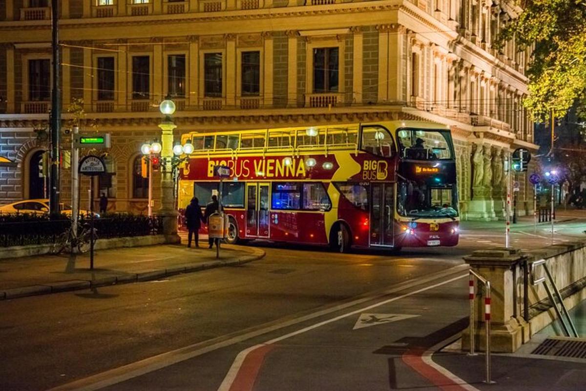 a double decker bus driving down a street at night