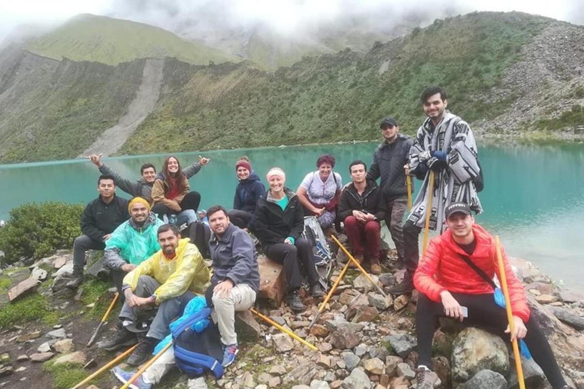 um grupo de pessoas posando para uma foto em um lago