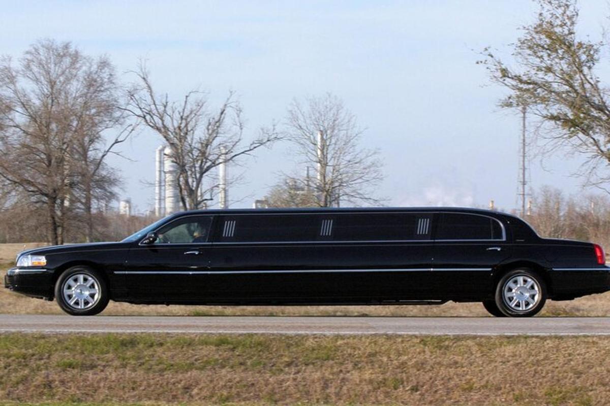 isang itim na limousine ang nakaparada sa gilid ng isang kalsada