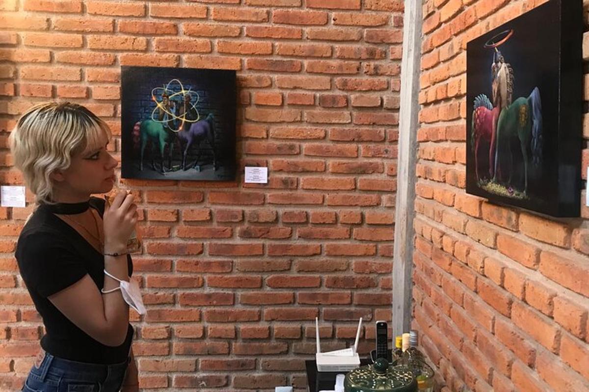 una donna che guarda un dipinto su un muro di mattoni