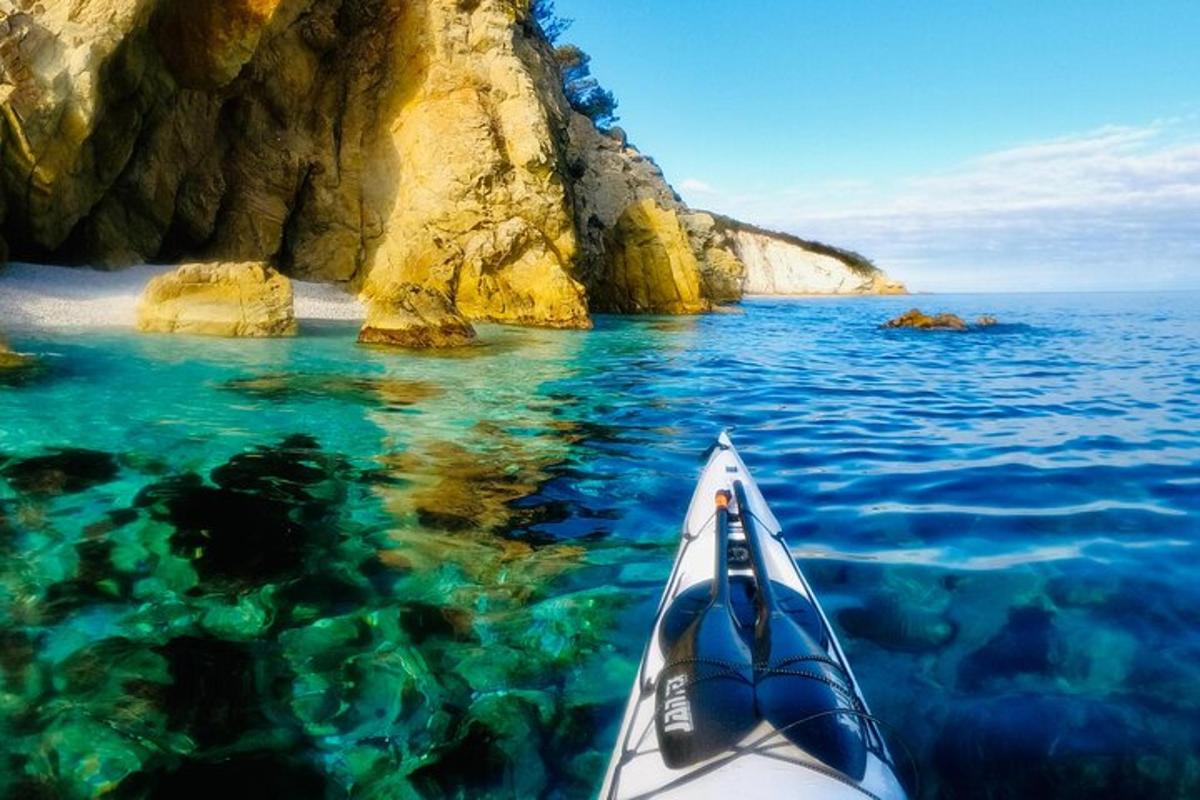 a kayak in the water near a rocky beach