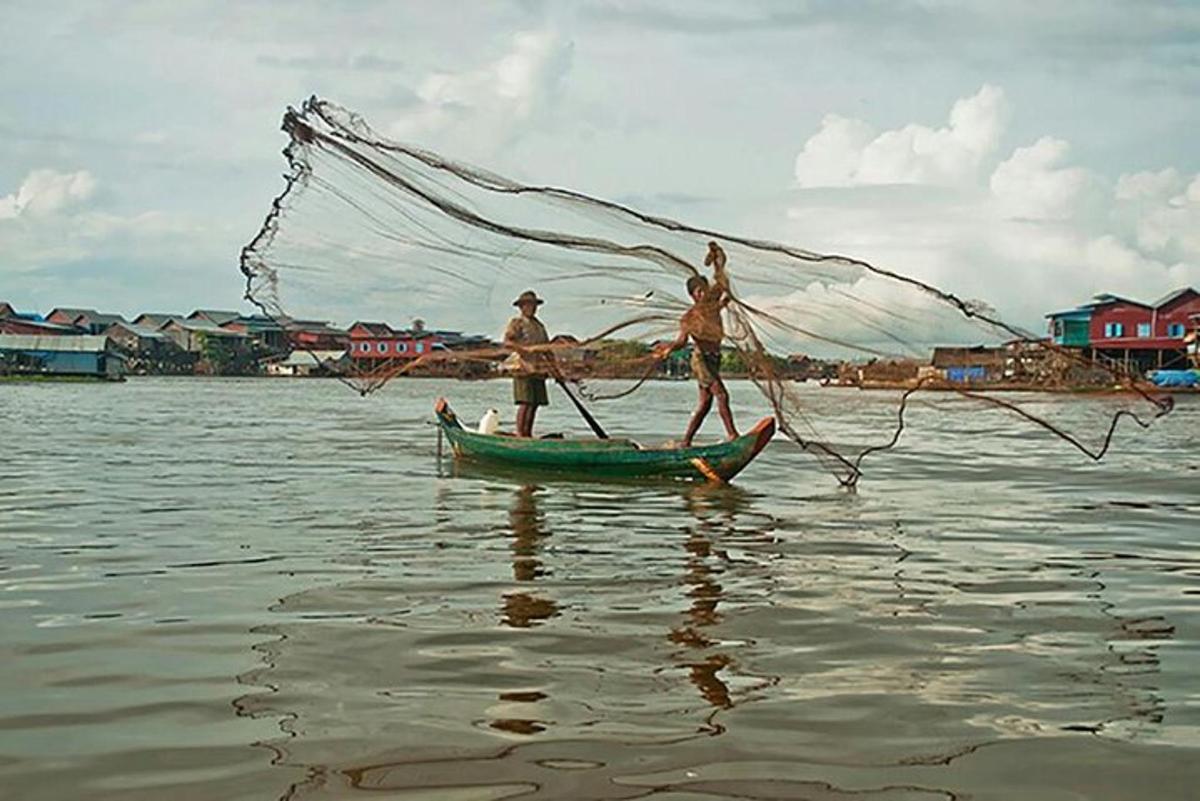 hai người trên một chiếc thuyền có lưới dưới nước