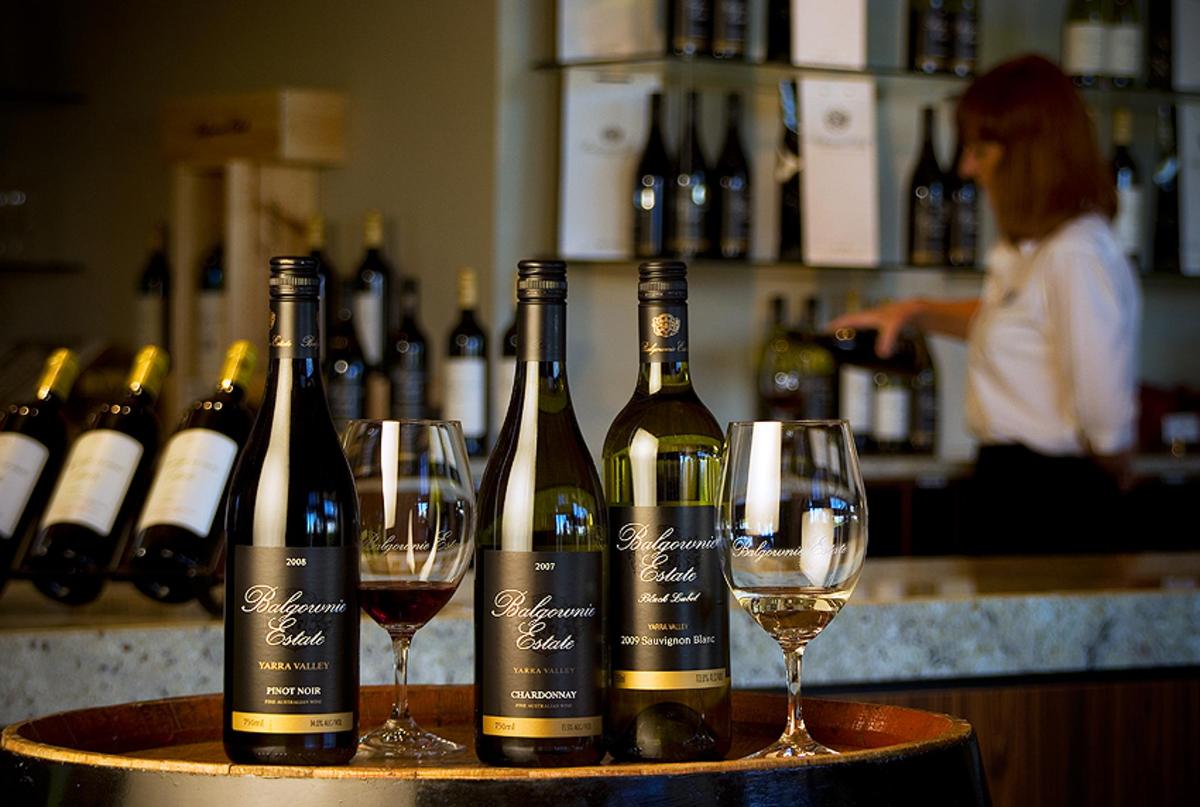 due bottiglie di vino appoggiate su un tavolo con bicchieri da vino