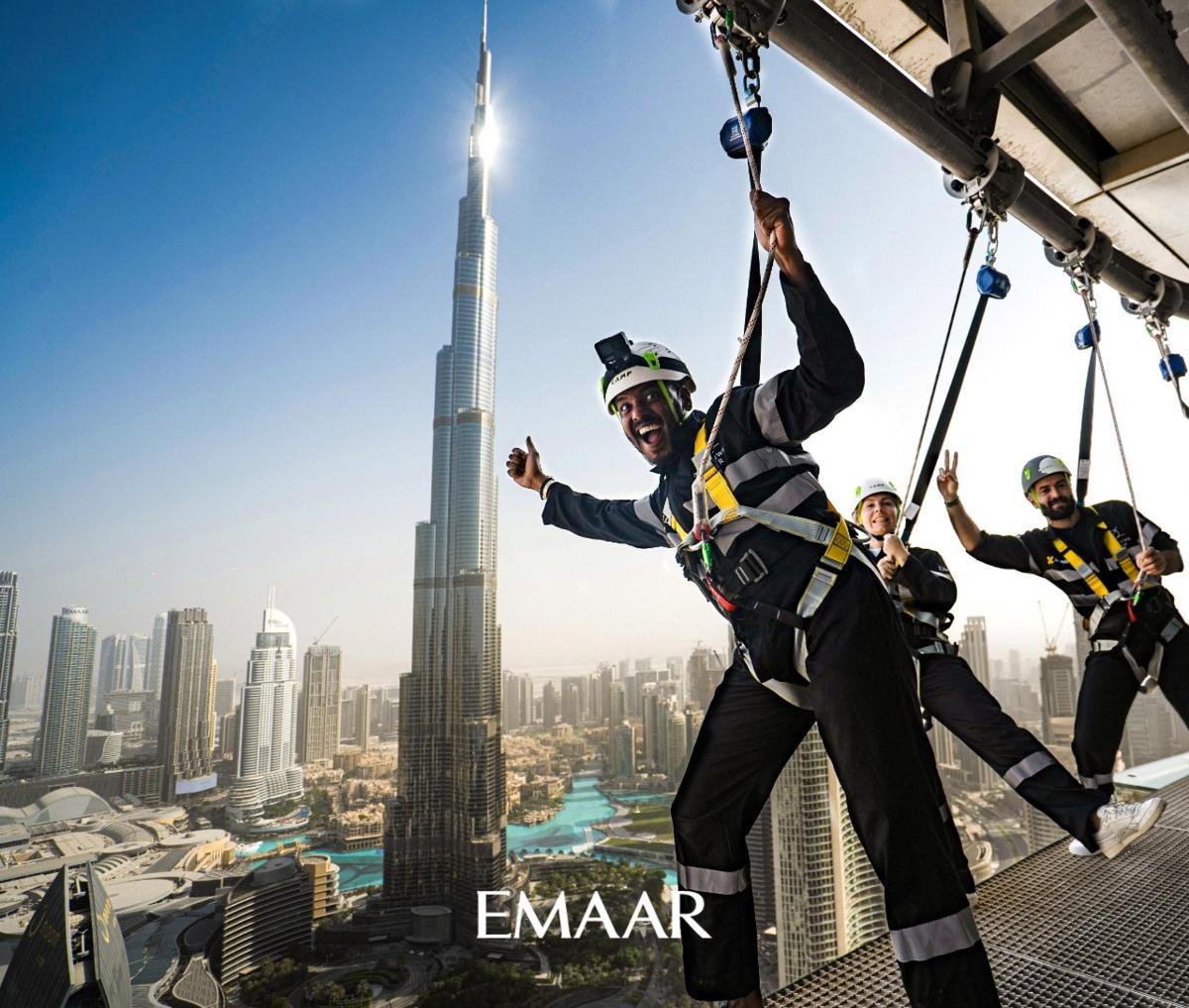 a group of people on a zip line in front of the shanghai tower