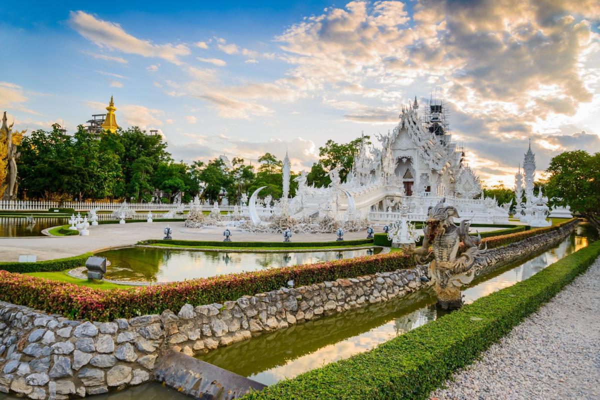 a white temple with a fountain in a park