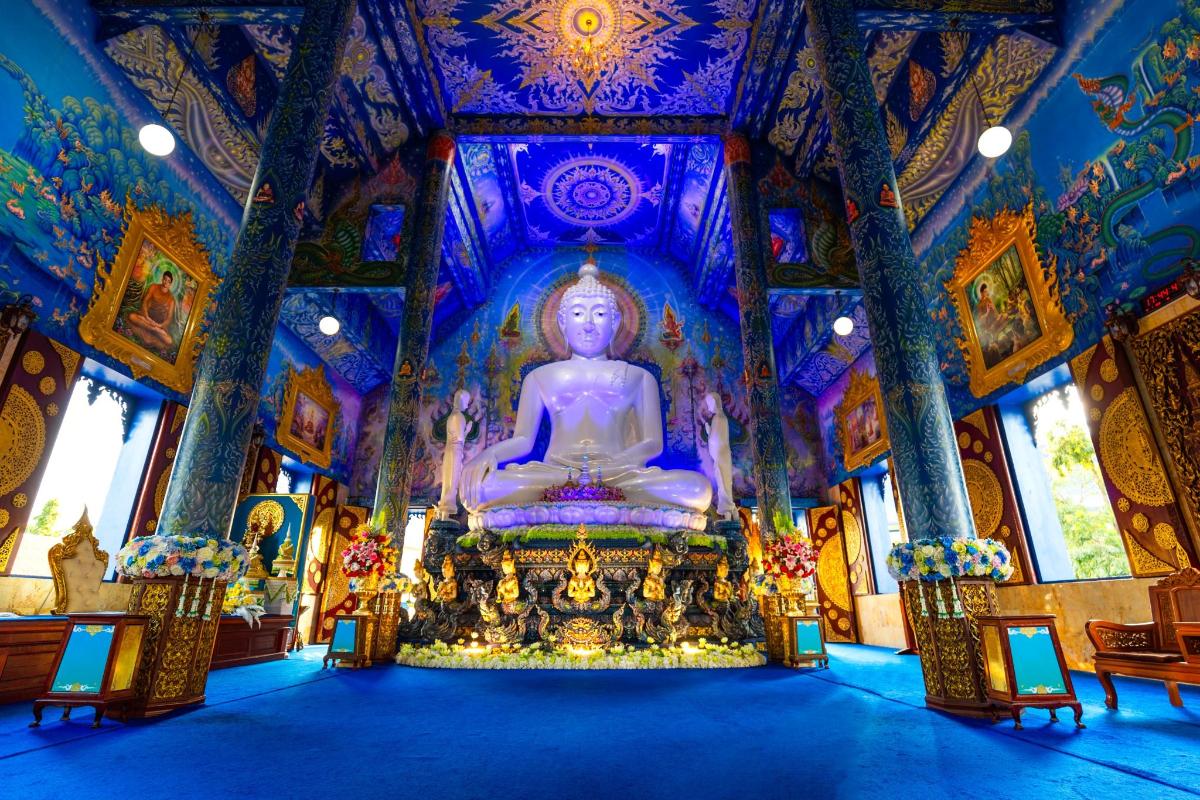 a large buddha statue in a large room in a temple