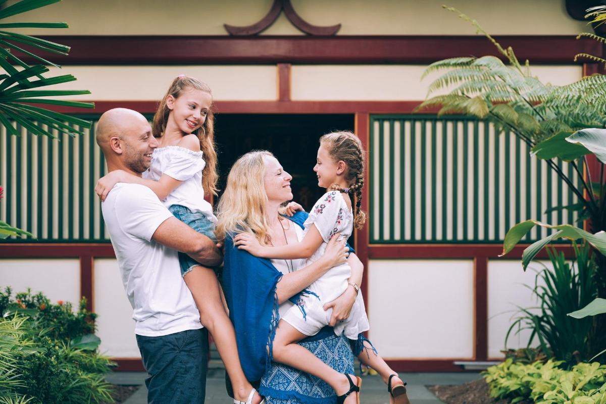 una famiglia posa per una foto davanti a una casa