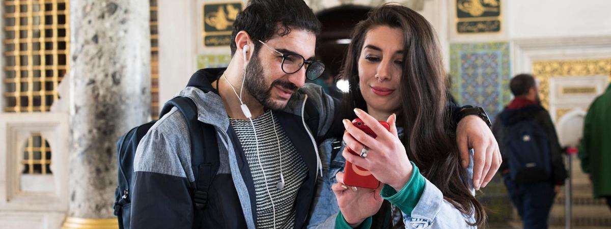 a man and a woman looking at a cell phone