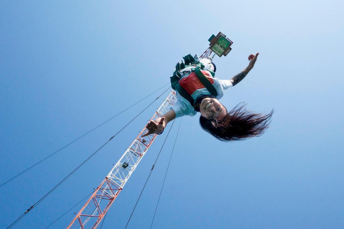 a person in the air next to a tower