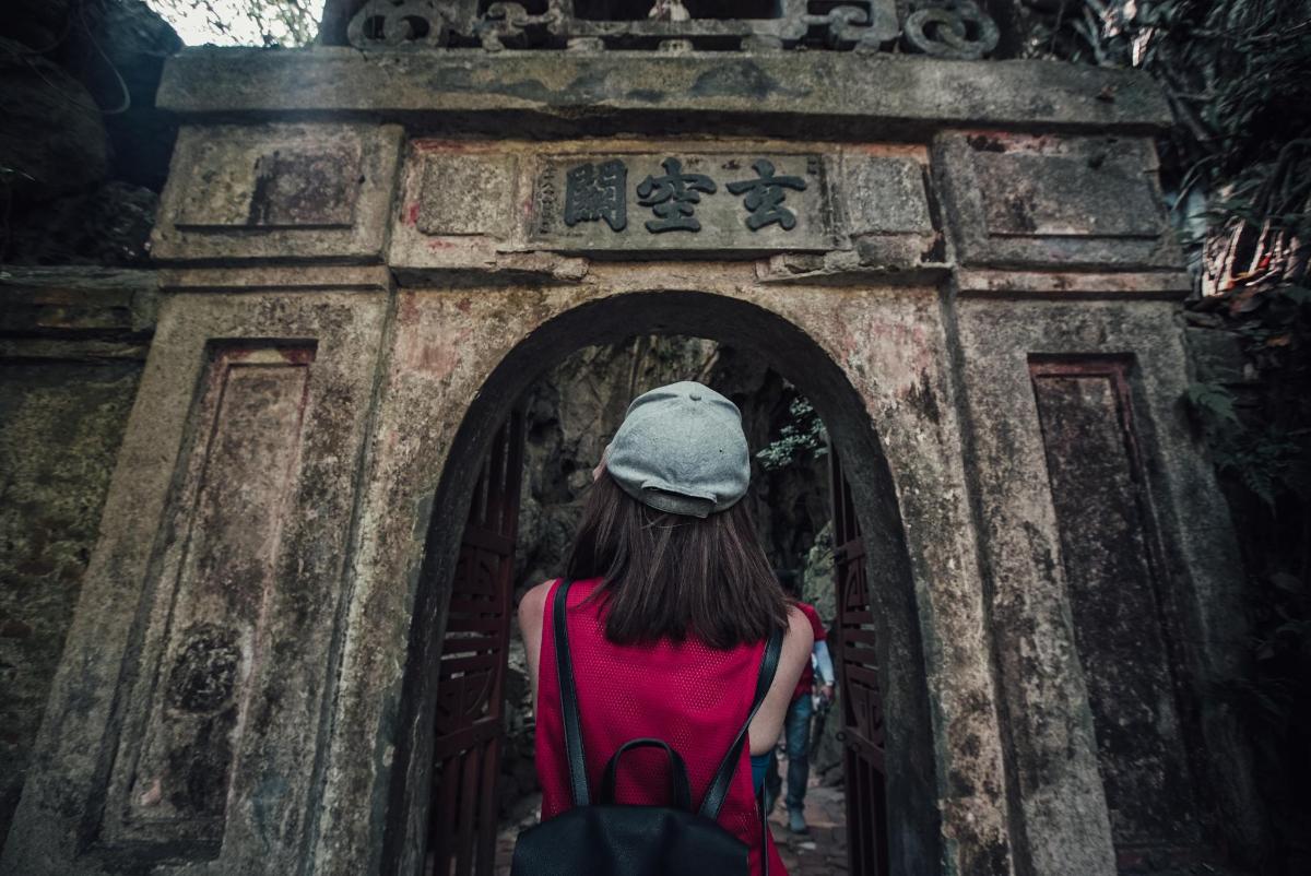 una donna che cammina attraverso un arco in un tempio