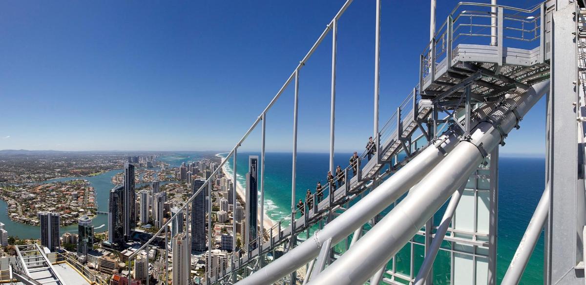 people standing on a bridge looking at the city