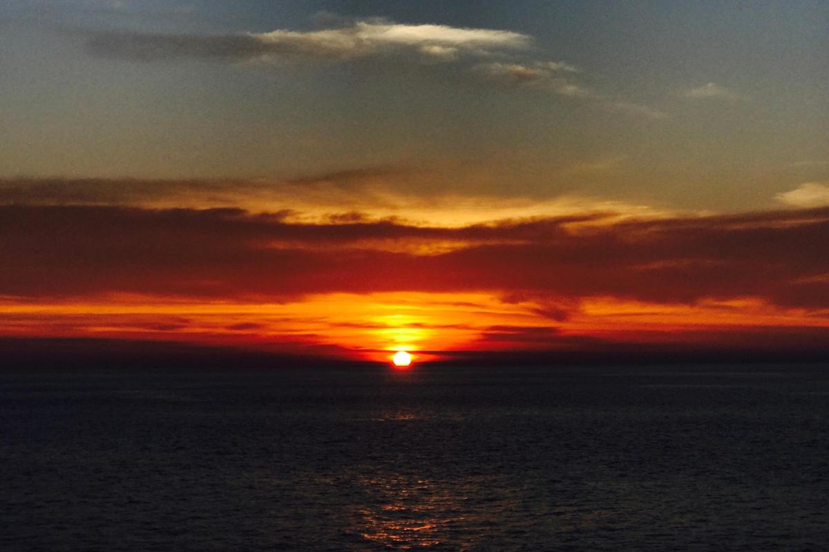 a sunset over the ocean with the sun setting