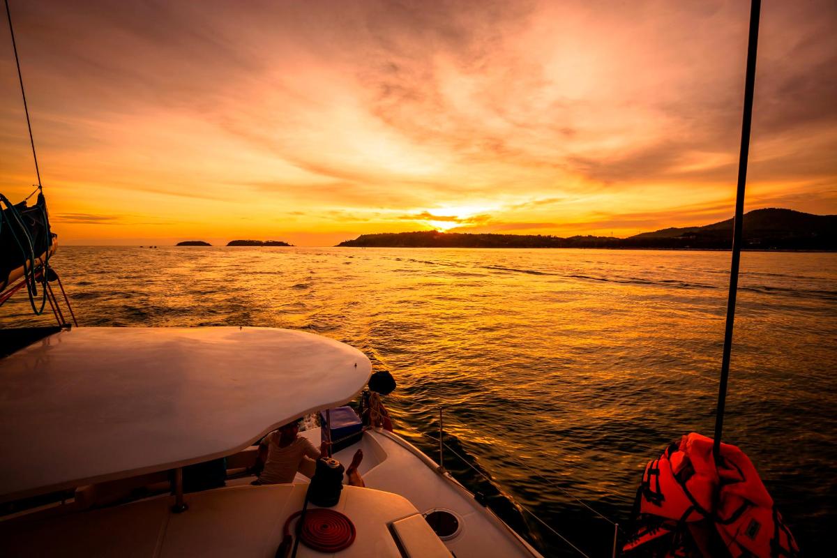 a boat in the water with a sunset