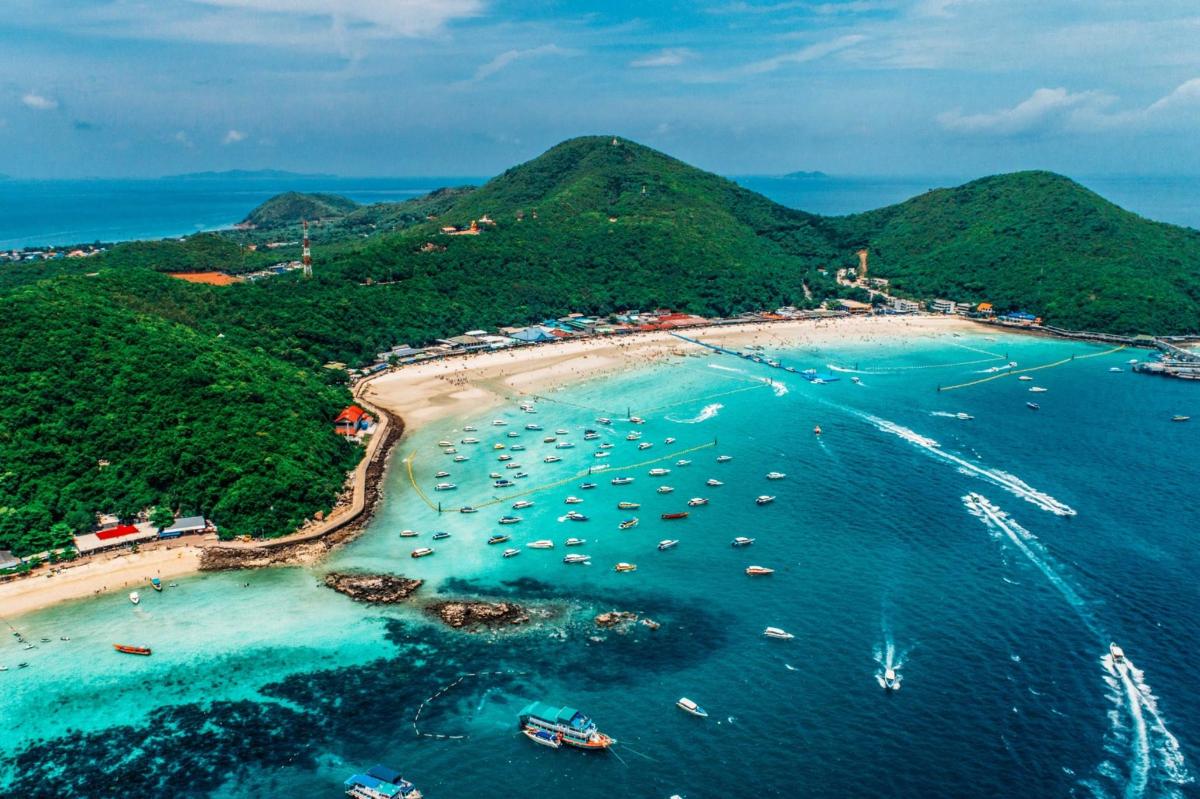 an aerial view of a beach with boats in the water